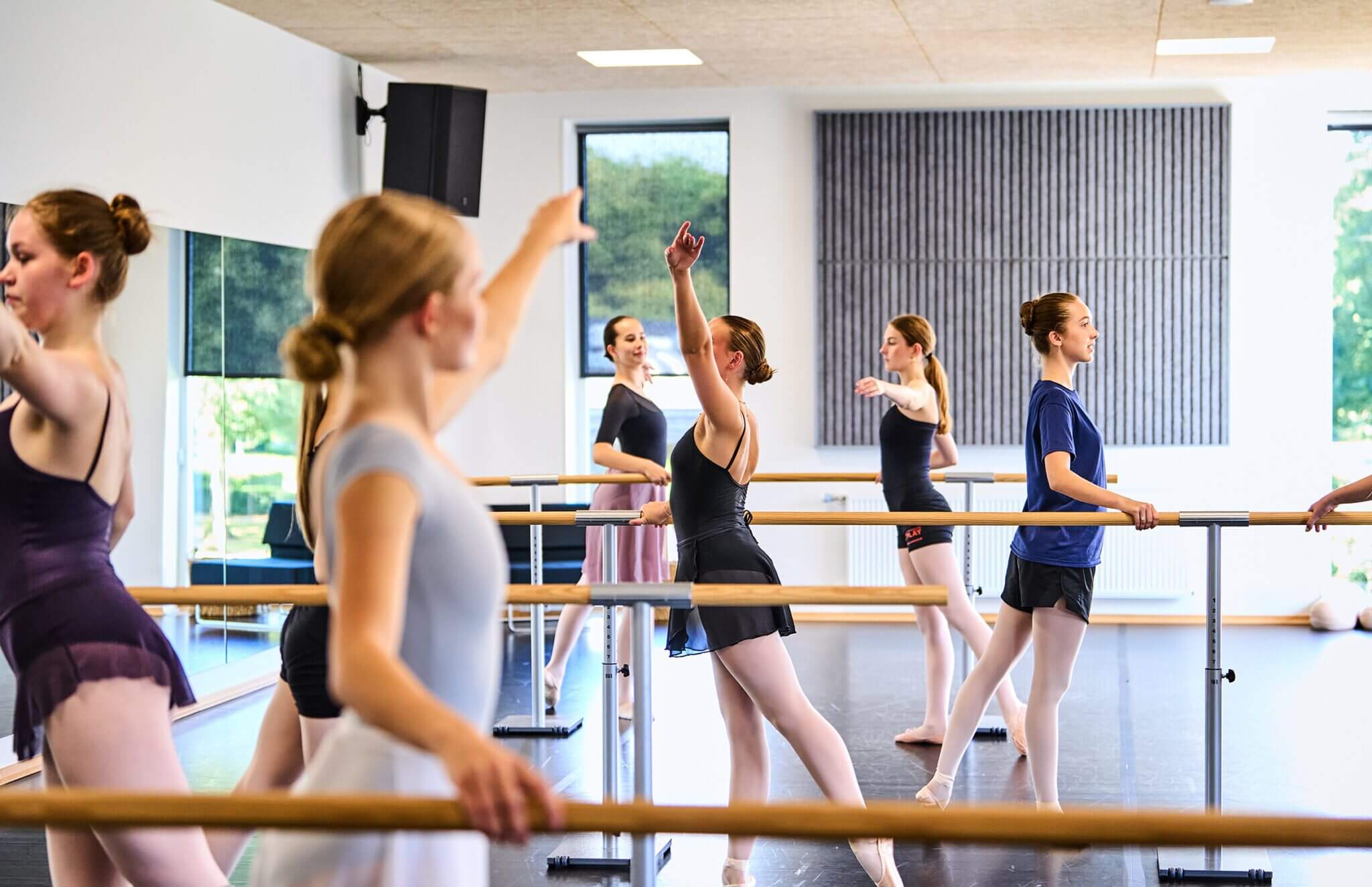 Elever træner ballet ved barren på danselinjen
